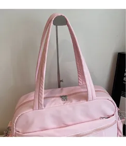 Detail of pink travel bag showing smooth metal zippers and reinforced padded handles