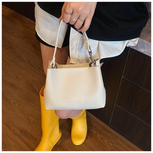 Dettaglio della borsa a secchiello crema in pelle litchi con logo Fashion & Bags