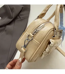 Detail of silver hardware and wrinkled faux leather texture on beige round bag