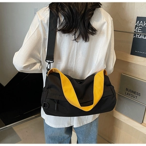 Detail showing the adjustable wide black fabric shoulder strap on the sporty pillow bag