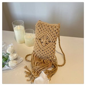 Détail d'un petit sac de téléphone en macramé avec motifs losanges et longues franges