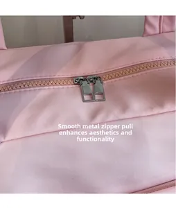 Detailed close-up of smooth silver metal zippers on a pink large travel bag