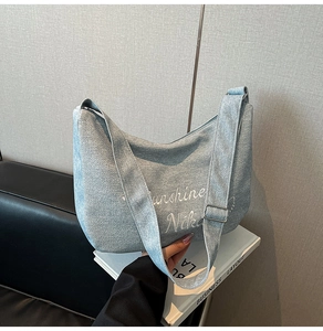 Détail du sac hobo en toile bleu clair avec broderies Sunshine et Niko