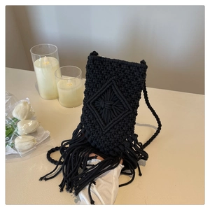 Détail du sac à téléphone noir tissé main avec motifs en losange et longues franges