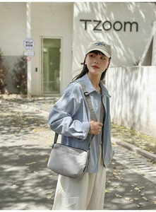 Vue extérieure d'un sac bandoulière minimaliste en nylon gris avec sangle réglable