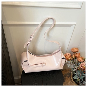Close-up of pink glossy underarm bag showing smooth faux leather texture and side pockets