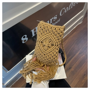 Vue détaillée d'un petit sac seau tissé à la main avec de longues franges et motif bohème