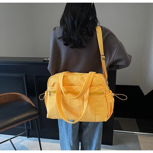 Close-up of yellow large capacity travel bag with multi-pocket and waterproof nylon texture