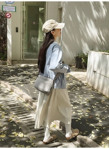 Photo de style d'une veste utilitaire bleu clair avec une jupe longue beige et une bandoulière
