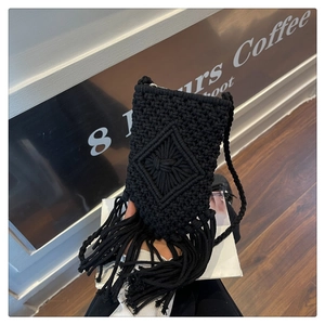Détail du sac de téléphone en macramé noir fait main avec de longues franges et motifs