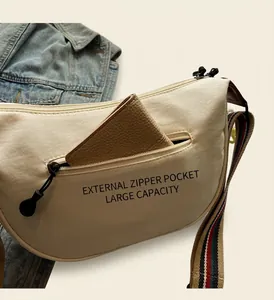 Detail view showing a brown wallet fitting into the front zipper pocket of a beige canvas bag