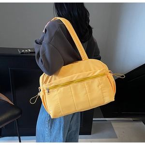 Yellow quilted nylon travel bag showing large capacity and side drawstring detail