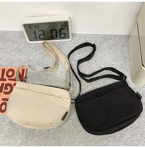 Gros plan sur les sacs bandoulière en toile minimalistes en noir et beige avec sangles