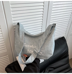 Détail du sac fourre-tout en denim bleu clair avec texte Sunshine blanc et motif ours