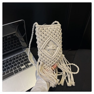 Détail macro du tissage macramé et des franges sur un petit sac bandoulière crème