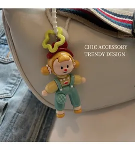 Close-up of a cute cartoon girl bag charm with a yellow star hook on a beige bag