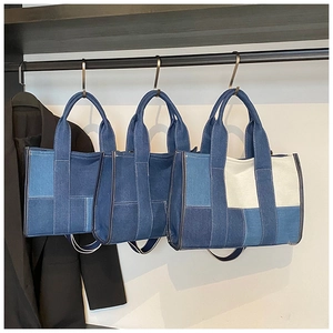 Detailed close-up of three color-blocked denim tote bags with contrast stitching details