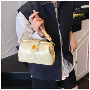 Détail d'un sac à main crème avec boucle en pierre d'ambre et finitions en métal doré