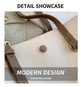 Detail of cream leather tote bag featuring a brown shoulder strap and gold round buckle