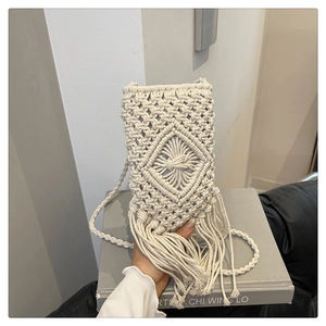Détail d'un sac à bandoulière en coton tressé avec motifs losanges et longues franges