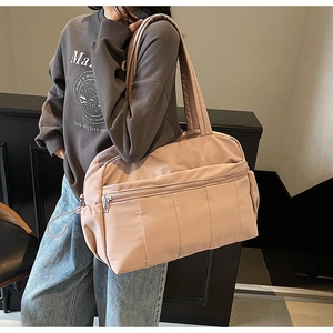 Detail of large capacity dusty pink travel tote bag with quilted design and side drawstring