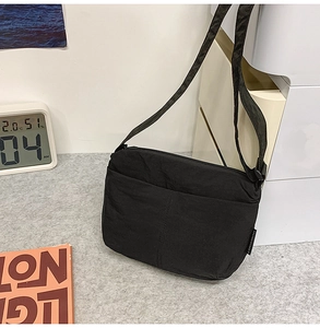 Détail du sac bandoulière noir léger en tissu texturé avec bandoulière réglable