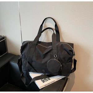 Detail der schwarzen Reisetasche mit strapazierfähigem Stoff und kleiner runder Geldbörse