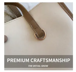 Detailed close-up of white leather tote bag with brown straps and golden D-ring buckle