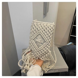 Gros plan sur un sac de téléphone tissé crème avec glands et textures bohèmes