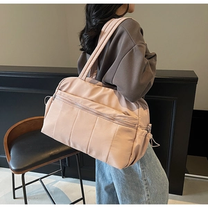 Detailed view of pink quilted travel bag showing soft waterproof fabric and outer pocket