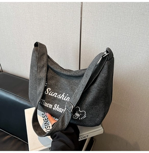 Détail du sac demi-lune en toile gris foncé avec imprimé ours et sangle large