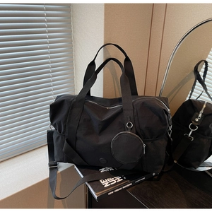 Detail der schwarzen Reisetasche mit dicken Griffen, Netztasche und runder Geldbörse