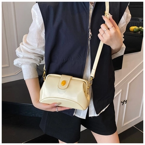 Détail d'un sac docteur en cuir PU jaune crème avec bouton ambre et crochets dorés