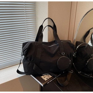 Detail der schwarzen großen Reisetasche mit verstellbarem Gurt, Seitentasche und Pouch