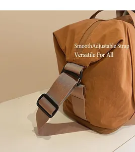 Détail de la bandoulière réglable et de la fermeture éclair du sac de sport en nylon brun