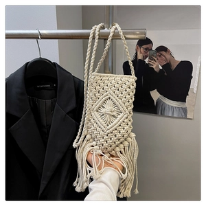 Détail du sac de téléphone tissé main avec motifs de losanges et longues franges en coton