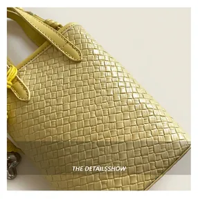 Dettaglio della borsa tote intrecciata giallo vivace con trama in finta pelle e nodo