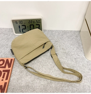 Détail du sac dumpling kaki montrant la texture lisse, l'étiquette latérale et le zip