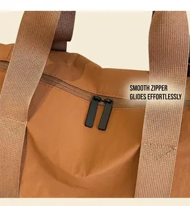 Détail des fermetures éclair bidirectionnelles et poignées du sac de yoga marron