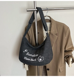 Détail du sac bandoulière lune en toile gris foncé avec broderie ours blanc élégante