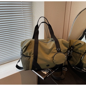 Detail der olivgrünen Reisetasche mit schwarzer Netztasche und passender kleiner Tasche