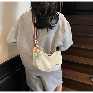 Detailed back view of a white half-moon crossbody bag with a colorful striped wide strap