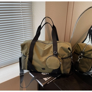 Detail der olivgrünen Reisetasche mit wasserdichter Nylon-Textur und Mini-Geldbörse