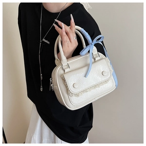 Close-up of white wrinkled leather handbag with lace trim and blue checkered ribbon detail