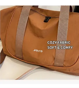 Détail du sac de yoga marron caramel montrant la texture du tissu et le logo NOCO