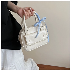 Detail of off-white pleated PU handbag with lace trim and blue checkered bow ribbon