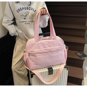 Pink large capacity travel bag on a suitcase showing durable nylon and multi-pocket details