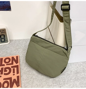 Détail du sac bandoulière en nylon vert olive montrant la texture matelassée et la sangle