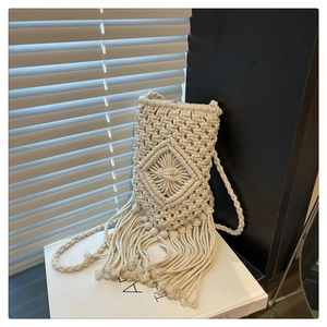 Vue macro détaillée des motifs en macramé crème et des franges sur le sac à bandoulière