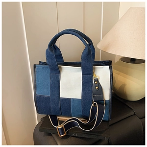 Detail shot of a contrast denim patchwork tote bag with gold hardware and shoulder strap